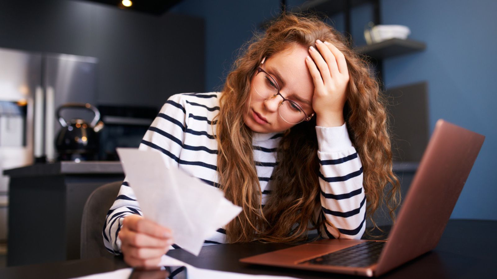 Unhappy woman calculates expenses on bills, upset about increased utilities prices. Female counting paychecks, debts, loans. Money Concept