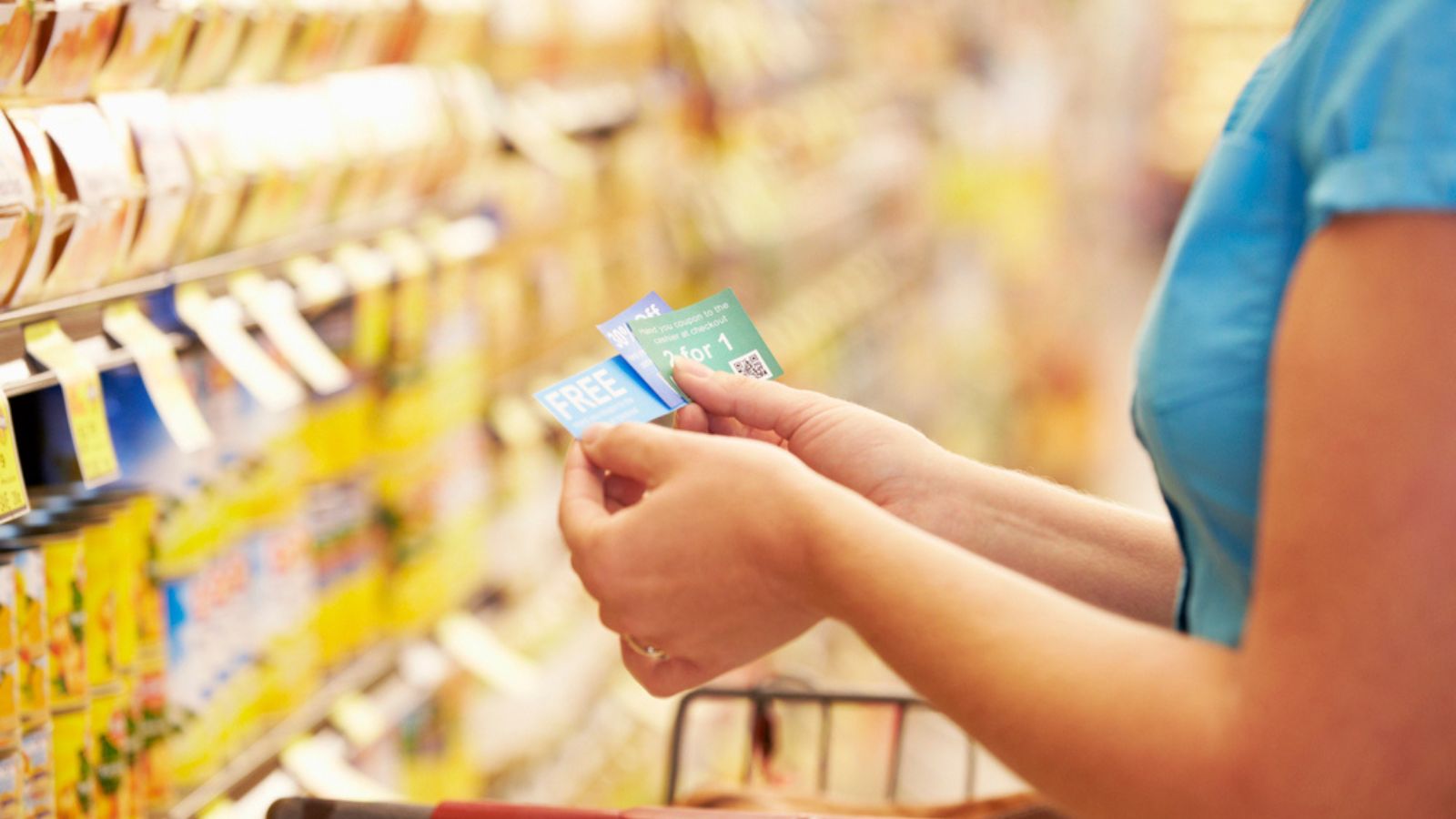 Woman With Coupons in Supermarket