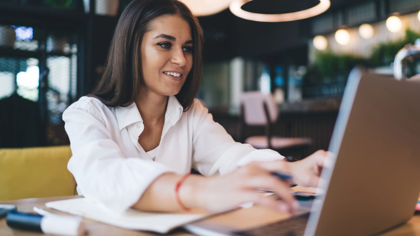 Attractive woman working with laptop; debt payoff plan