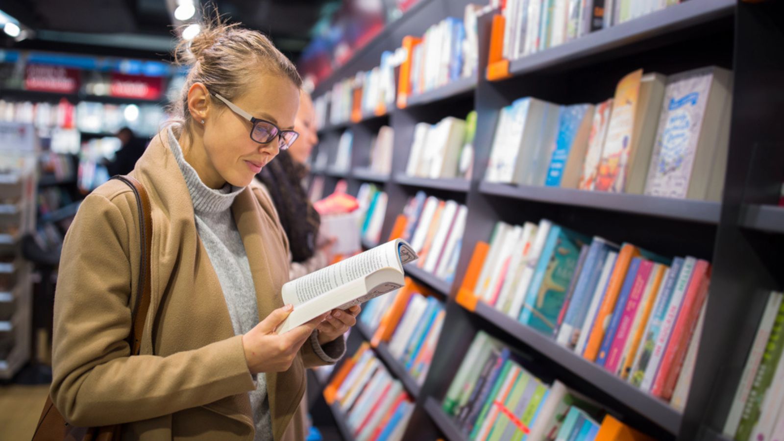Woman choosing a good book to buy in a bookstore
