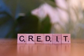 A wooden block spelling credit on a table; rebuild credit after bankruptcy