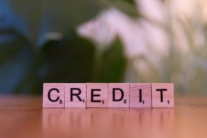 A wooden block spelling credit on a table; rebuild credit after bankruptcy