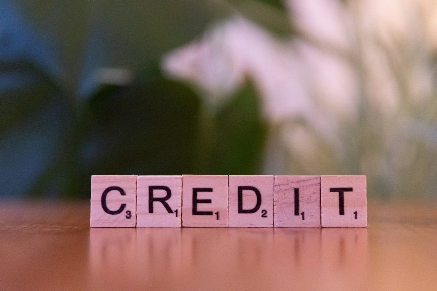 A wooden block spelling credit on a table; rebuild credit after bankruptcy
