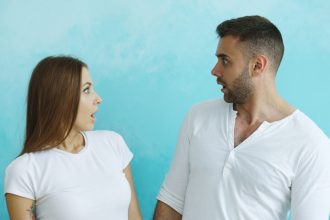 Couple looking at each other with surprise; talk to your partner about debt