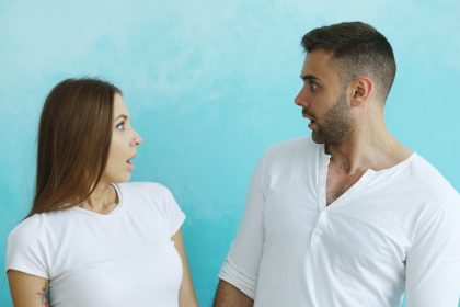 Couple looking at each other with surprise; talk to your partner about debt