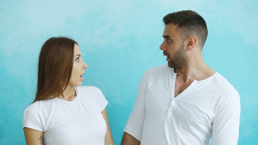 Couple looking at each other with surprise; talk to your partner about debt