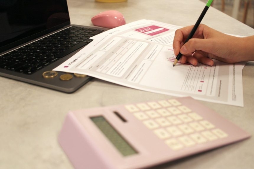 Someone is working on paperwork with a calculator. zero-based budget