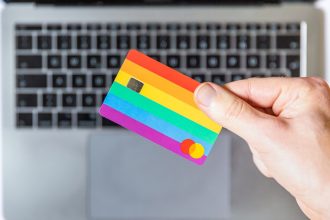 person holding yellow and pink card; Person reviewing credit card balances on a laptop to calculate; credit utilization ratio