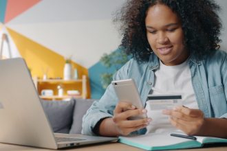 Teenager using phone and credit card for online shopping; automate debt payments