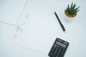 black calculator beside black pen on white printer paper; 50/30/20 Rule