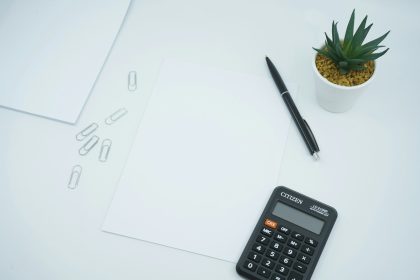 black calculator beside black pen on white printer paper; 50/30/20 Rule