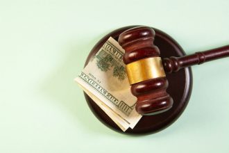 A gavel rests on a sound block with money. finances after divorce