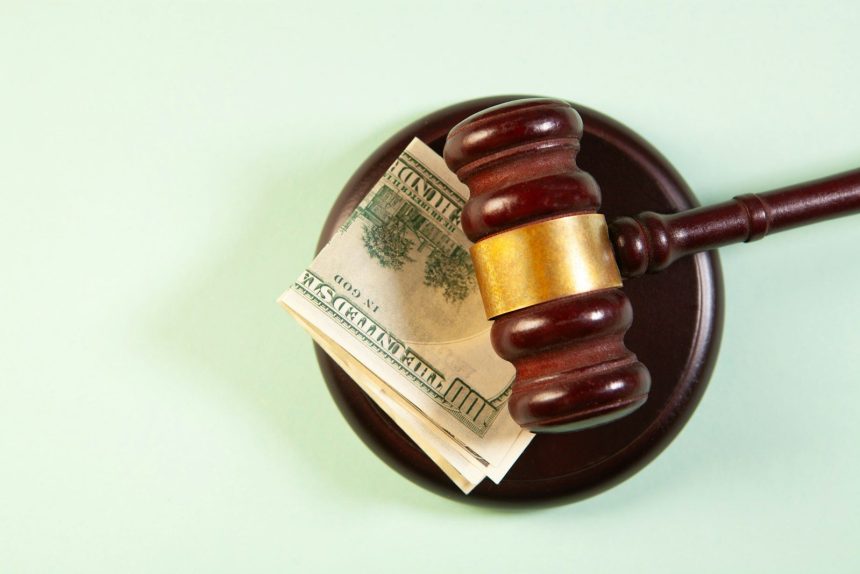 A gavel rests on a sound block with money. finances after divorce