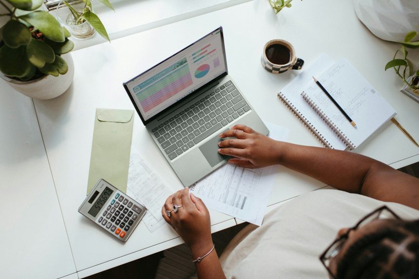 a person sitting at a table with a laptop; how to start investing after debt