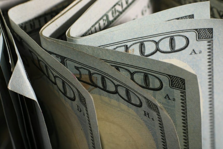 A close-up of us hundred dollar bills fanned out.; what is envelope budgeting