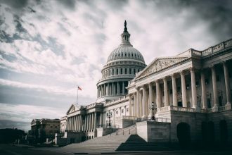 white concrete building under cloudy sky during daytime; government shutdown debt