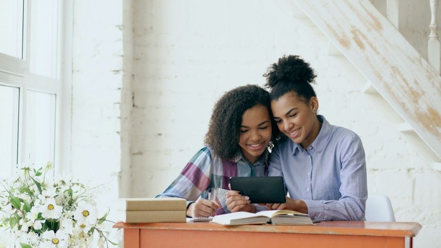 Two women reading a book together; wedding debt
