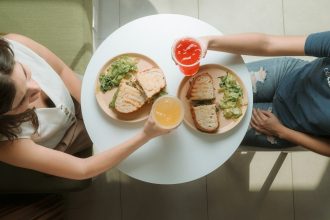A man and a woman sitting at a table with a plate of food; friend debt