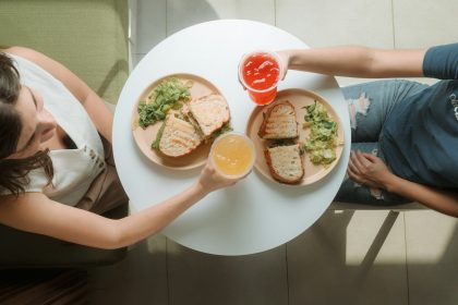 A man and a woman sitting at a table with a plate of food; friend debt