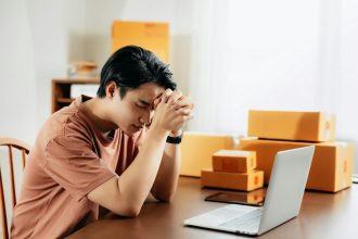 a man sitting in front of a laptop computer; 401(k) Hardship Withdrawal
