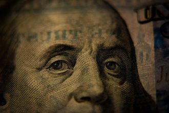 A close-up of Benjamin Franklin on a United States one hundred dollar bill; moneymaxxing