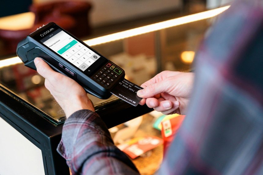 a person holding a cell phone in their hand; store credit card