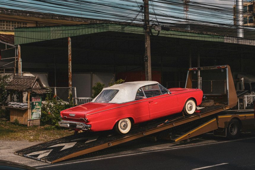 a red car is being loaded onto a flatbed truck; car repossessions in 2026