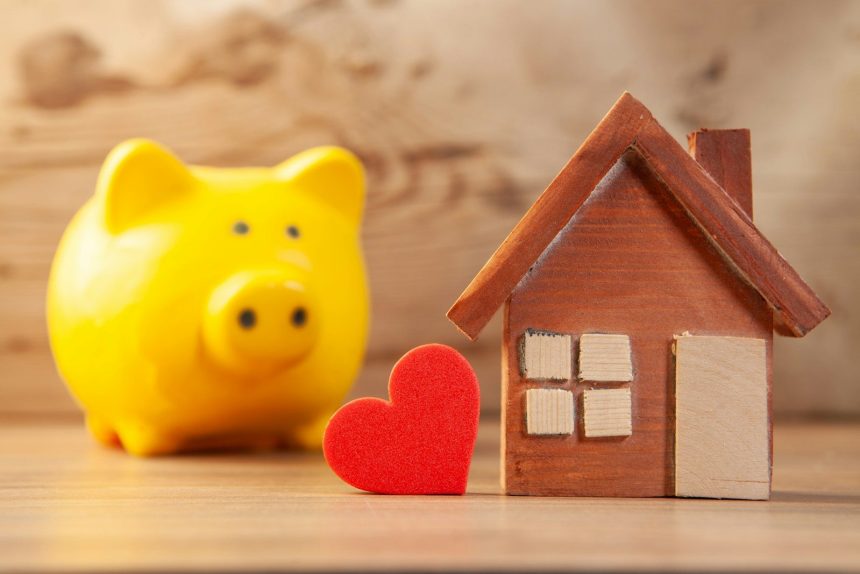 Yellow piggy bank with wooden house and red heart; Parent PLUS loan debt