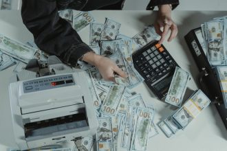 Hands counting cash withdrawn through paycheck advance apps in 2026