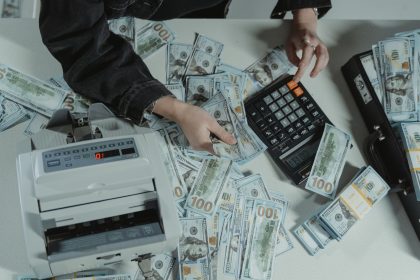 Hands counting cash withdrawn through paycheck advance apps in 2026