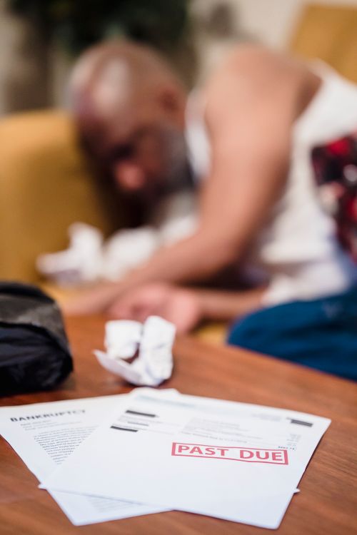 Person weighing a medical bill against a credit card statement while skipping medical care for debt in 2026